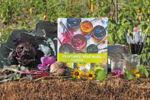 Livre mis en scène au potager avec des légumes et des fleurs dont on peut extraire la couleurs.