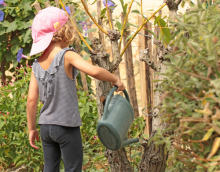 Photo d'une petite fille en train d'arroser un arbre